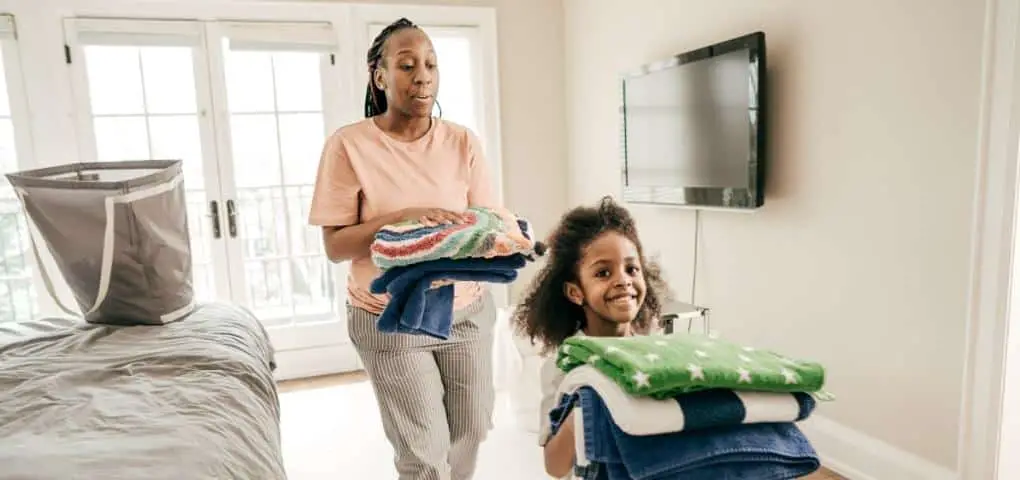 child helping mom fold laundry