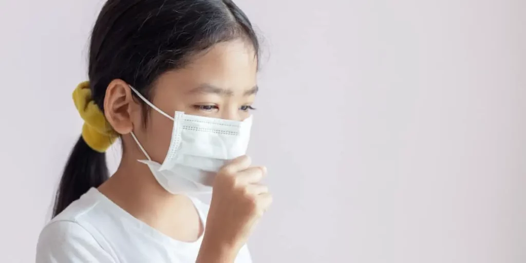 girl coughing with mask on