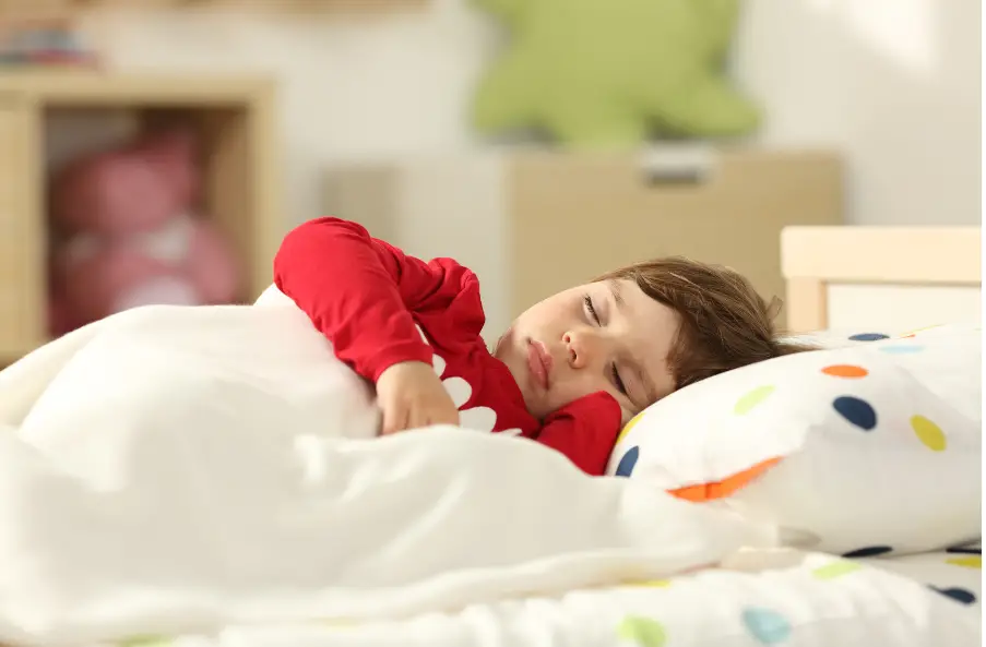 little boy wearing a red long-sleeved shirt sleeping