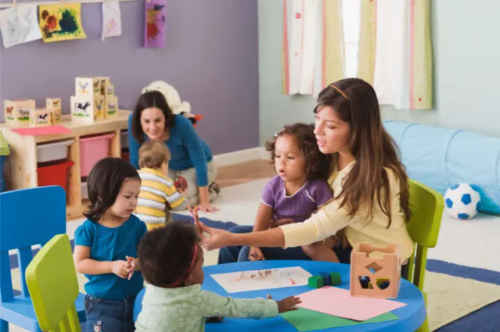 two daycare workers attending to children