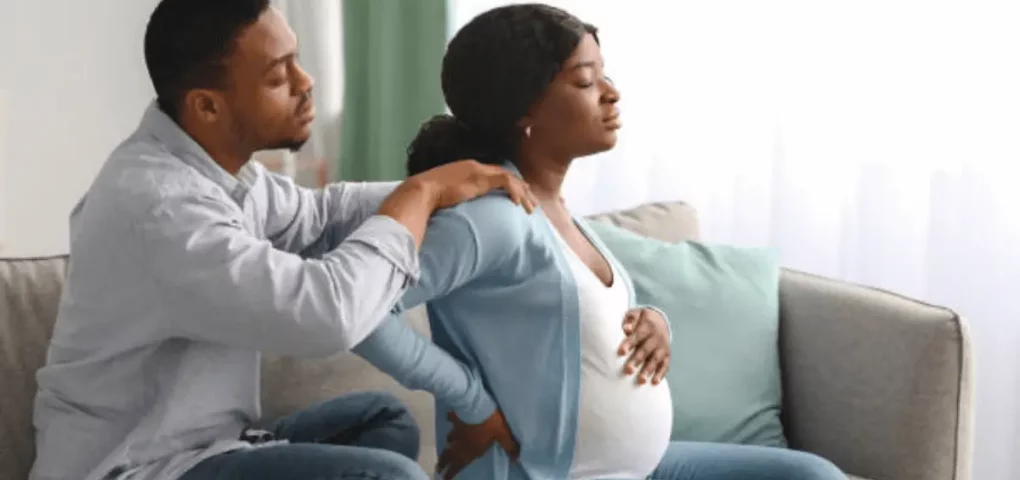 husband massaging pregnant wife