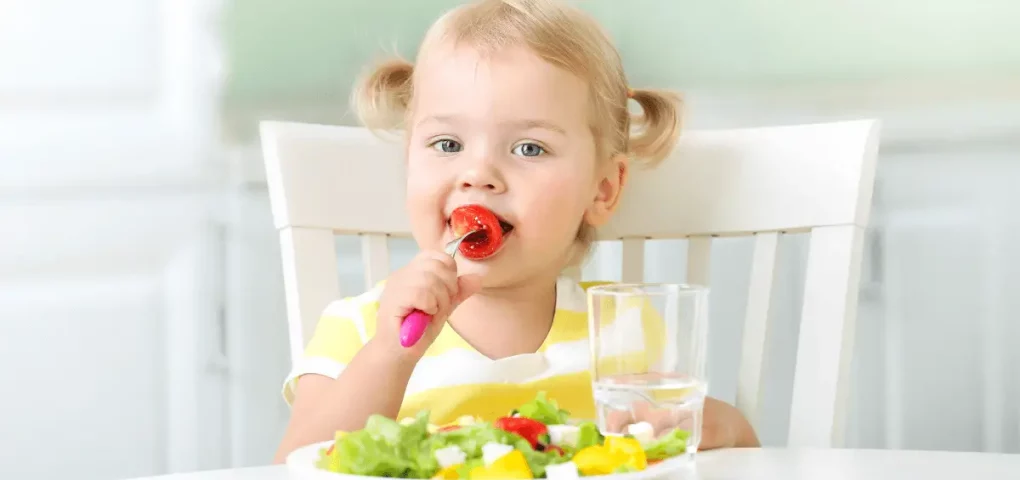 kid eating tomato