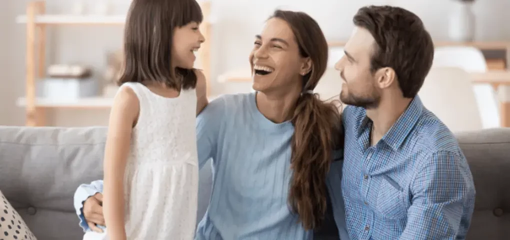 mom, dad and daughter laughing