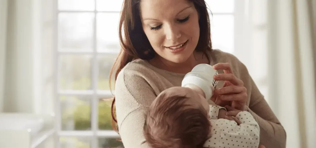 mom feeding her baby with bottled milk
