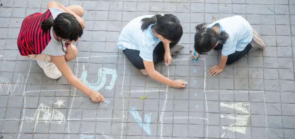 prechoolers writing numbers on the street