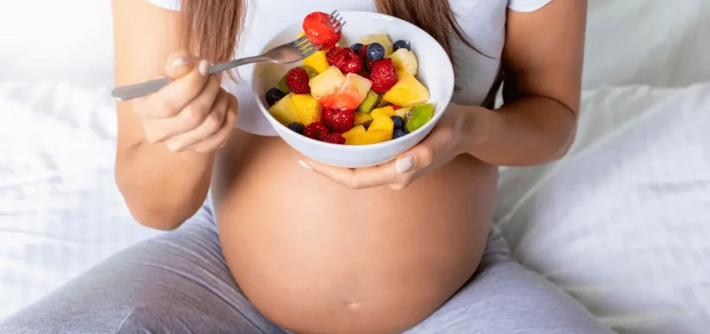 pregnant mom eating mixed fruits