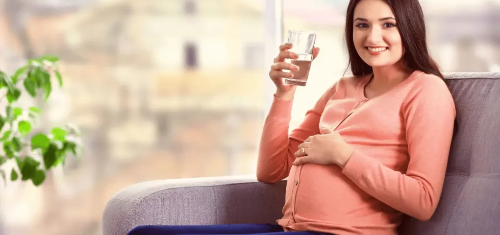 pregnant mom holding a glass of water