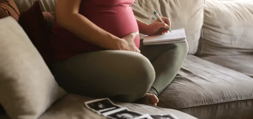 pregnant mom writing a list of gender-neutral baby names