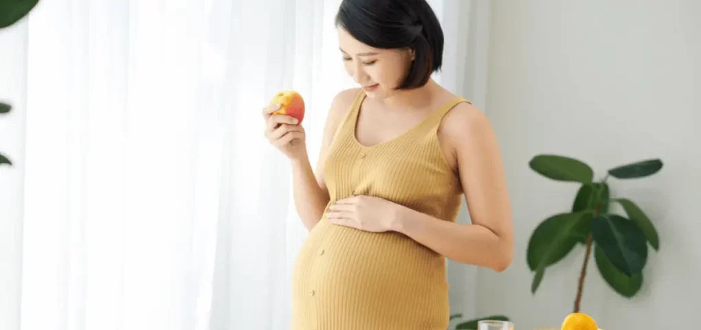 pregnant woman eating apple